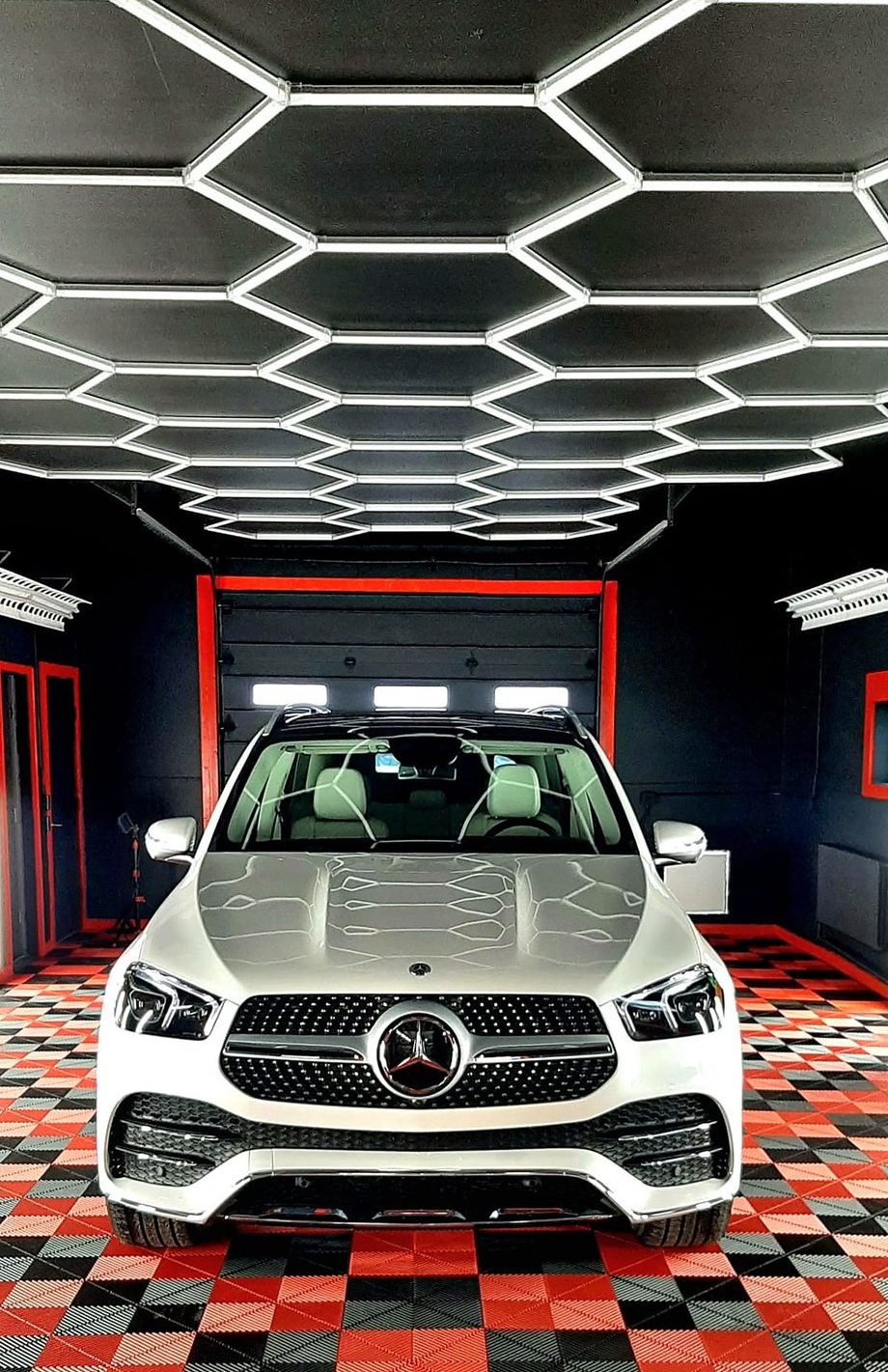 White Mercedes SUV with ceramic coating parked inside Retro Detailing’s custom shop bay.